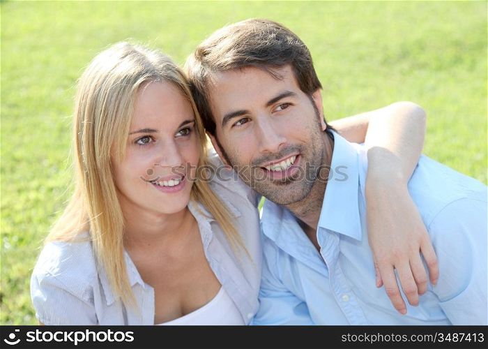 Happy young couple sitting in yard