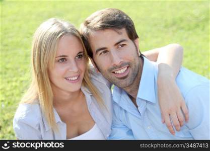 Happy young couple sitting in yard