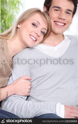 Happy young couple sitting indoors