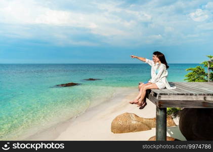 happy young couple sitting on a wood bridge and sea beach at Koh MunNork Island, Rayong, Thailand