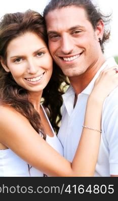 Happy young couple smiling at camera and embracing each other