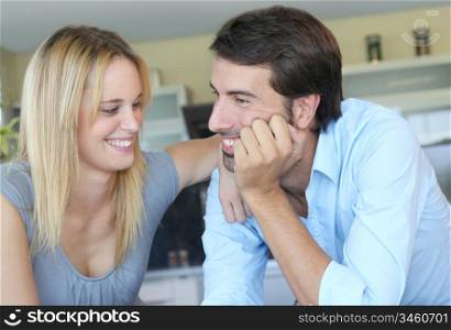 Happy young couple standing in home kitchen