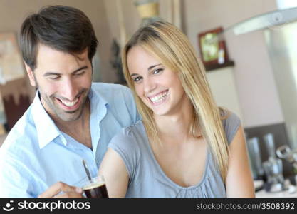 Happy young couple standing in home kitchen