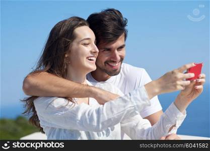 happy young couple taking selfie with cell phone
