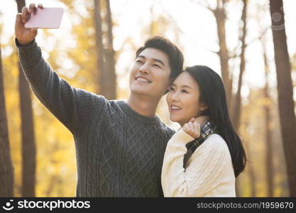 Happy young couple taking selfies with their mobile phone