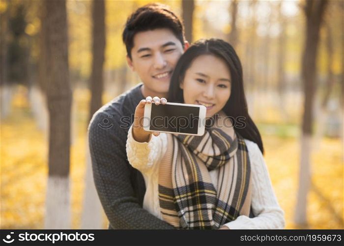 Happy young couple taking selfies with their mobile phone