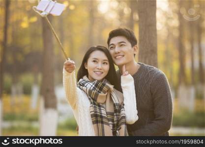Happy young couple taking selfies with their mobile phone