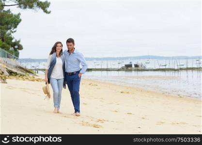 happy young couple walking on the beach