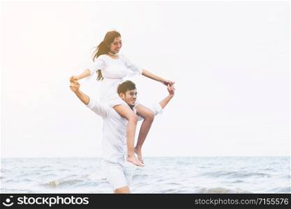 Happy young couple walking on the beach during honeymoon travel vacation.. Couple going honeymoon on tropical beach in summer