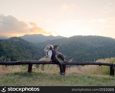 Happy young couple watching the sunset in the mountains at Mae Wong National Park, Kamphaeng Phet, Thailand