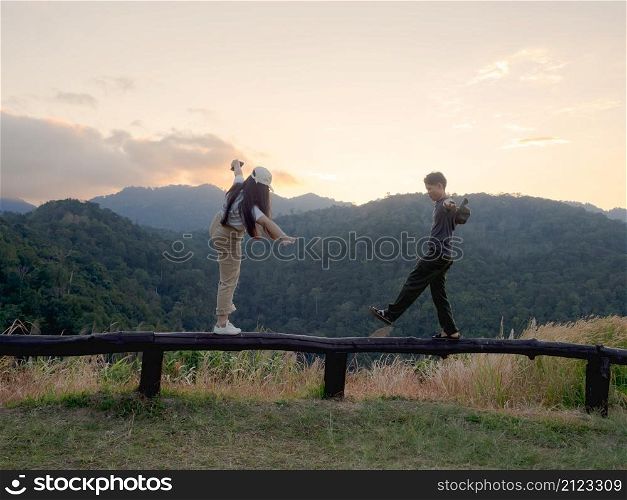Happy young couple watching the sunset in the mountains at Mae Wong National Park, Kamphaeng Phet, Thailand