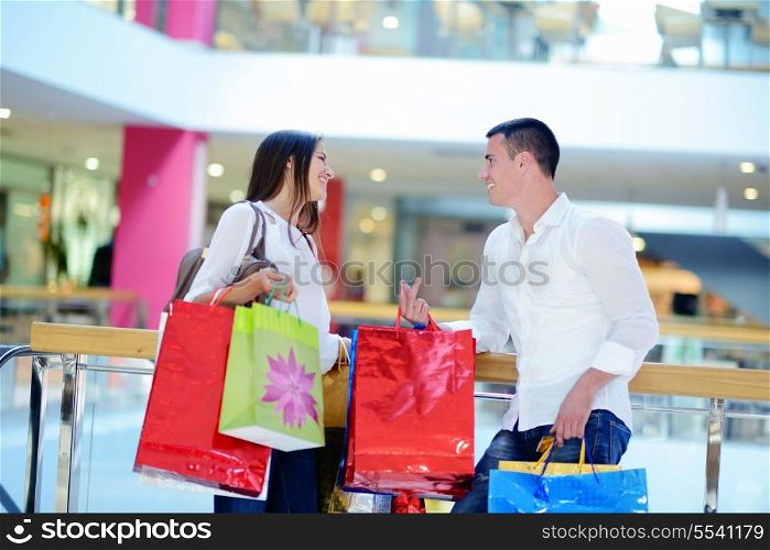 happy young couple with bags in shopping centre mall