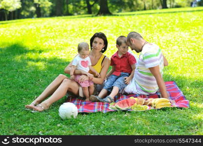 happy young couple with their children have fun at beautiful park outdoor in nature