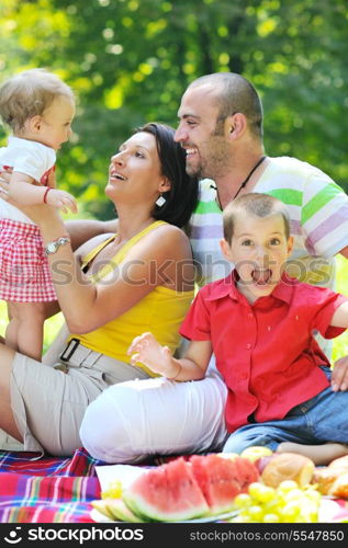 happy young couple with their children have fun at beautiful park outdoor in nature