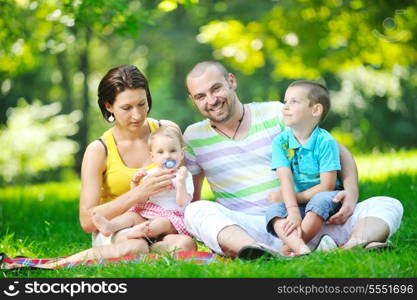 happy young couple with their children have fun at beautiful park outdoor in nature