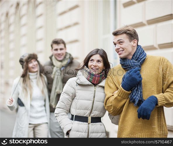 Happy young couples in warm clothing enjoying vacation