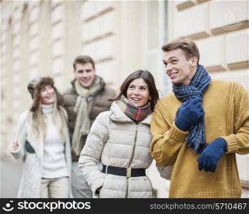 Happy young couples in warm clothing enjoying vacation