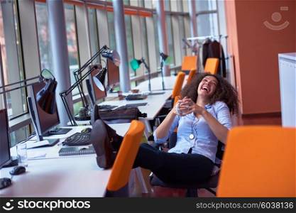 happy young curly business woman in the modern office have coffee break and relaxing