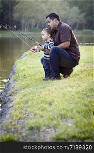 Happy Young Ethnic Father and Son Fishing at the Lake.