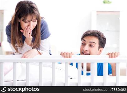 Happy young family at baby bed cot. The happy young family at baby bed cot