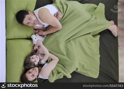 happy young family at home relaxing in bed
