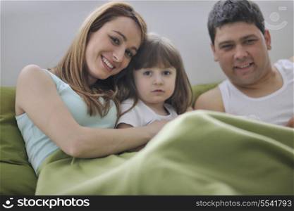 happy young family at home relaxing in bed