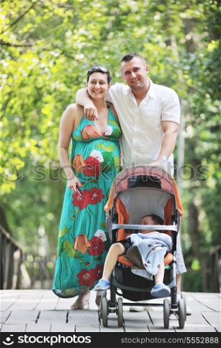 Happy young Family at park relaxing and have fun with pregnant woman