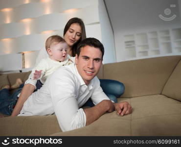 happy young family couple with beautiful new born baby have fun at modern home