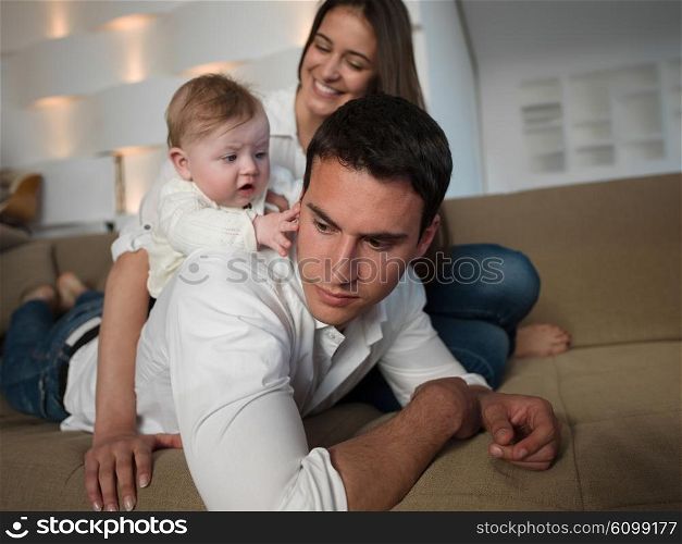 happy young family couple with beautiful new born baby have fun at modern home