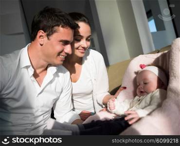 happy young family couple with beautiful new born baby have fun at modern home