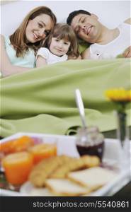 happy young family eat breakfast in bed at morning