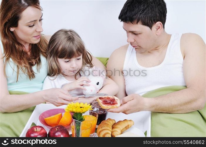happy young family eat breakfast in bed at morning