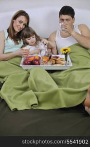 happy young family eat breakfast in bed at morning