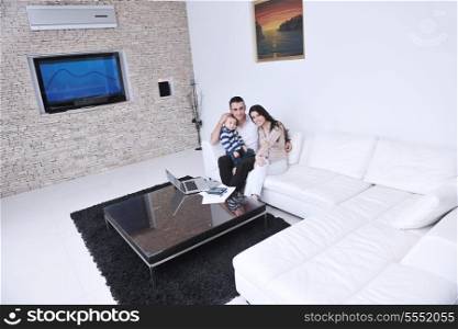 happy young family have fun and relaxing at new home with modern lcd tv in background