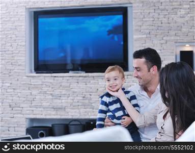 happy young family have fun and relaxing at new home with modern lcd tv in background