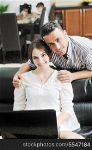 happy young family have fun and working on laptop at modern home livingroom indoor