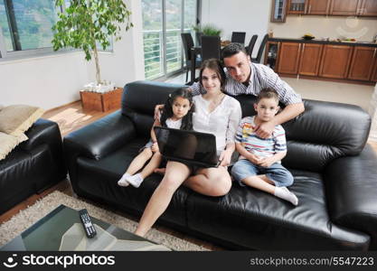 happy young family have fun and working on laptop at modern home livingroom indoor