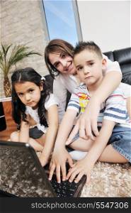 happy young family have fun and working on laptop at modern home livingroom indoor
