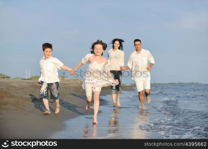 happy young family have fun on beach run and jump at sunset