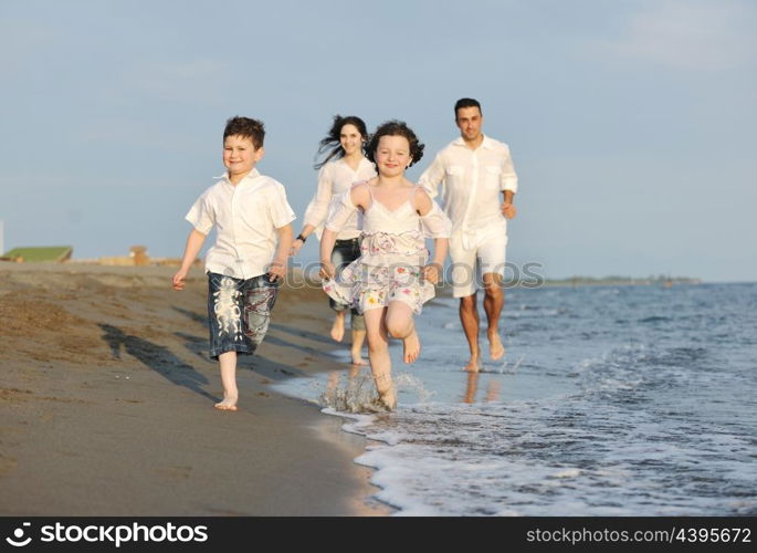 happy young family have fun on beach run and jump at sunset