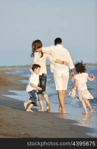 happy young family have fun on beach run and jump at sunset