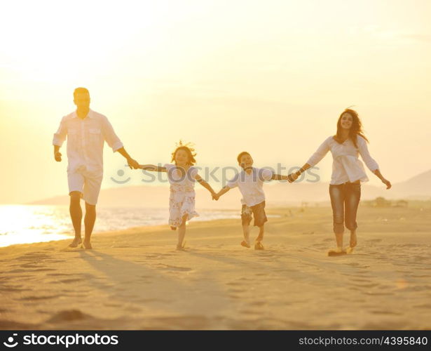 happy young family have fun on beach run and jump at sunset