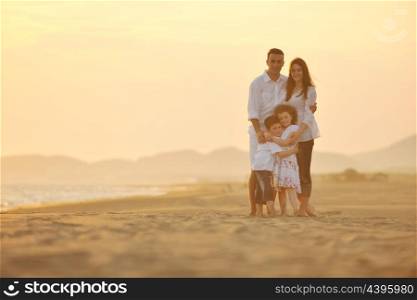 happy young family have fun on beach run and jump at sunset