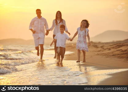 happy young family have fun on beach run and jump at sunset