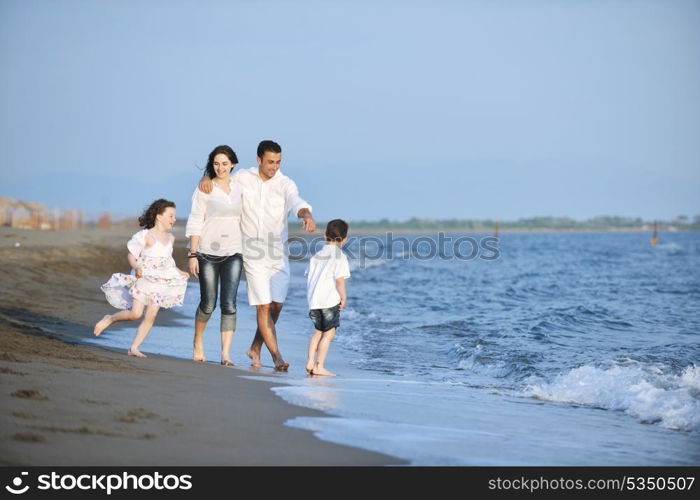 happy young family have fun on beach run and jump at sunset