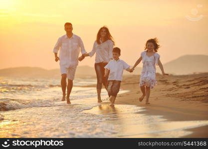 happy young family have fun on beach run and jump at sunset