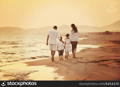 happy young family have fun on beach run and jump at sunset