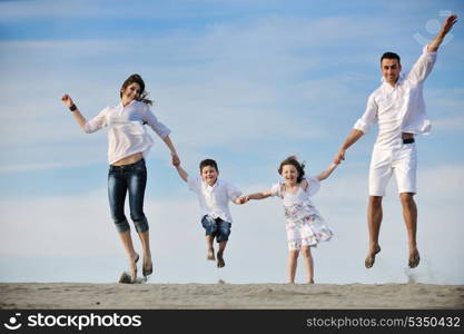 happy young family have fun on beachand showing home sign with conncected hands while protecting childrens