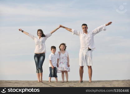 happy young family have fun on beachand showing home sign with conncected hands while protecting childrens