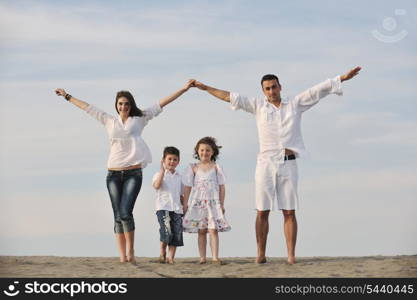 happy young family have fun on beachand showing home sign with conncected hands while protecting childrens